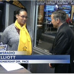 woman in yellow scarf being interviewed on TV